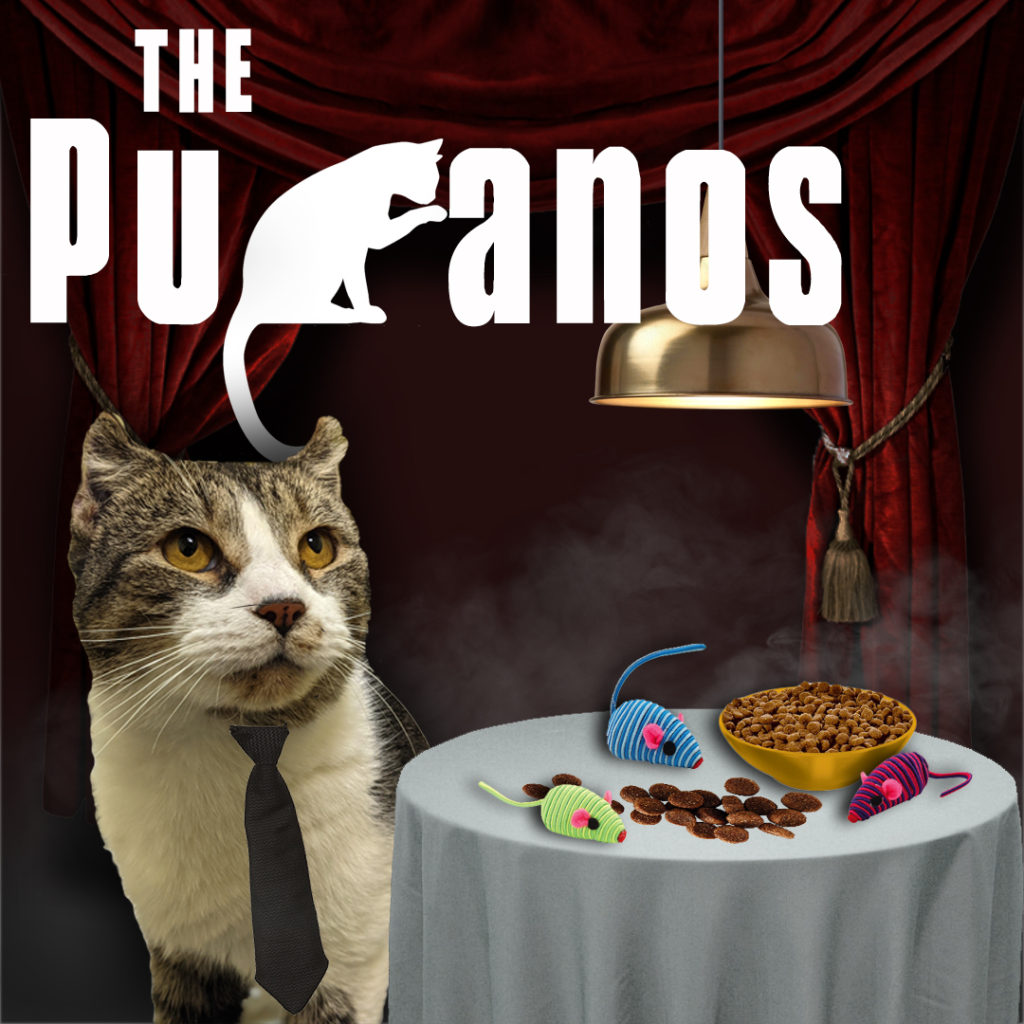 Cat with white and tabby markings, wearing a neck tie, sits next to a table draped with a white table cloth. On the table are several toy mice and a bowl of cat food. Behind this scene are red curtains pulled back with gold tassels. White text overlay "The Puranos" is styled like "The Sopranos."